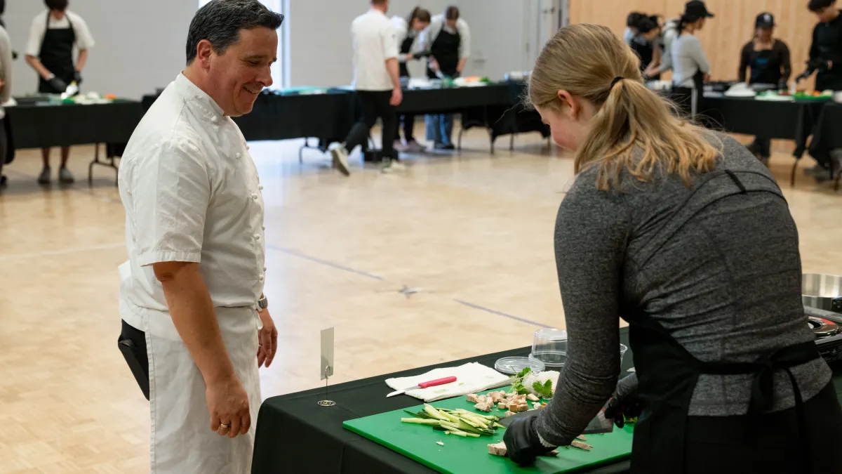 Chef watching student cut vegetables